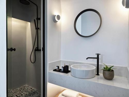 a white bathroom with a sink and a mirror at Notia Suite, Jacuzzi, Imerovigli in Imerovigli