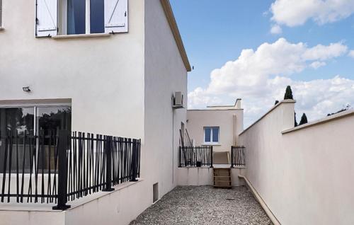 een wit huis met een poort en een binnenplaats bij Lovely Home In Montignargues With Private Swimming Pool, Can Be Inside Or Outside in Montignargues