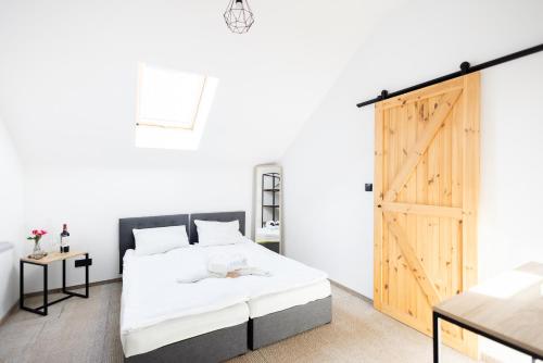 a bedroom with a bed and a wooden door at Folwark Matecznik - Spichlerz in Sedzinko