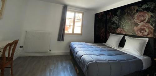 una camera da letto con un letto con una coperta blu di Au Bois Dormant a Crécy-en-Ponthieu