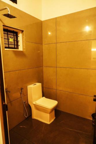 a bathroom with a toilet and a window at Sravan Villa in Vagamon