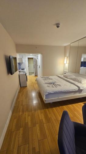 a bedroom with a large bed and a wooden floor at BLACK SEA ORBI APARTAMENT s in Angisa