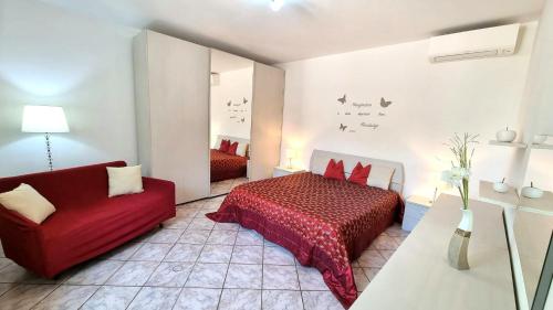 - une chambre avec un lit rouge et un canapé rouge dans l'établissement Fontana Comfort Apartment, à Castelnuovo del Garda