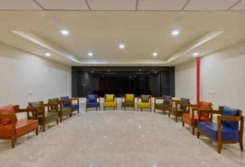 een conferentieruimte met kleurrijke stoelen en een podium bij hotel monville in Vadodara