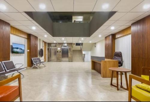 een kantoor met een grote hal met stoelen en tafels bij hotel monville in Vadodara