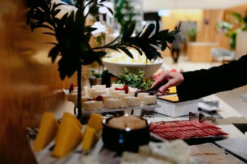 Una persona está preparando comida en un buffet. en Crowne Plaza Sydney Macquarie Park by IHG, en Sídney