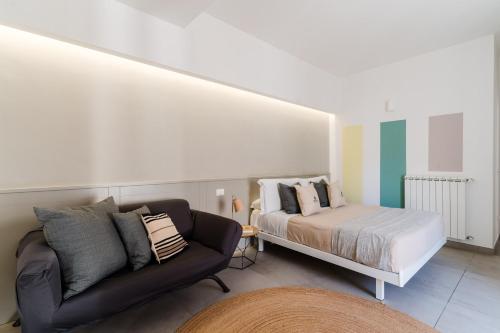 een woonkamer met een bed en een bank bij Beddhra Mia - Lecce Selection in Lecce