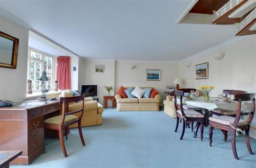 ein Wohnzimmer mit Tisch und Couch in der Unterkunft Stable Mews Cottage in Royal Tunbridge Wells