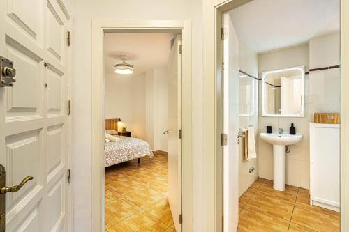 a bathroom with a sink and a bedroom at Apartment in Los Cristianos WIFI in Arona