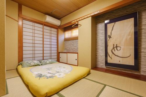 a japanese room with a bed and a window at Just a short walk 心斎橋 Glico Sign 1min 道頓堀30-second 黒門市場 難波駅 Dotonbori Guesthouse 梅の阁 in Osaka
