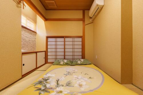 a room with a bed with flowers on it at Just a short walk 心斎橋 Glico Sign 1min 道頓堀30-second 黒門市場 難波駅 Dotonbori Guesthouse 梅の阁 in Osaka