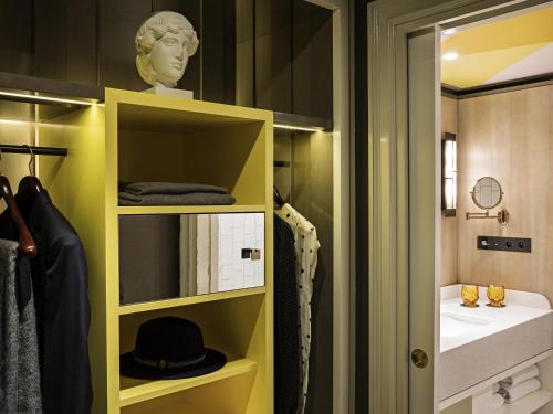 baño con armario amarillo y lavamanos en Sofitel Le Scribe Paris Opera, en París