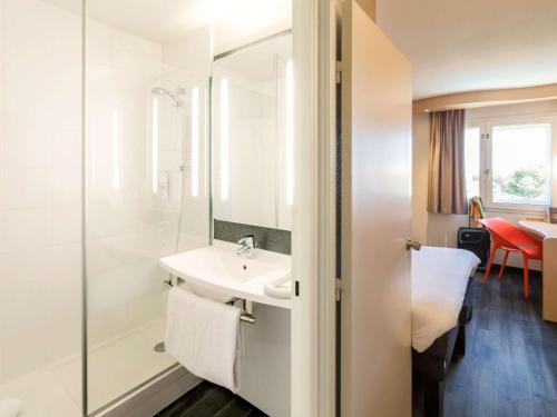 a bathroom with a sink and a mirror at ibis Beziers Est Mediterranee A9/A75 in Béziers