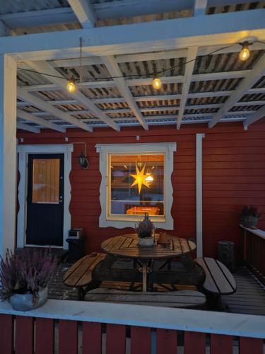 a patio with a table and a window on a deck at Kaamasen Kievari in Kaamanen