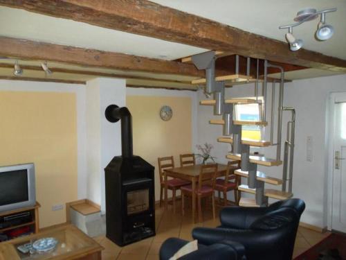 a living room with a spiral staircase and a dining room at Freistehendes Ferienhaus In Ruhiger Lage in Rubitz