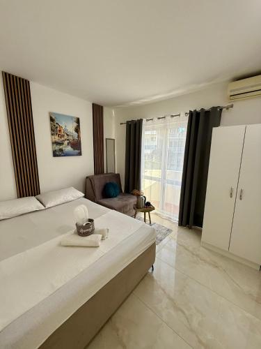 a bedroom with a large white bed and a chair at Guest house, Small beach in Ulcinj