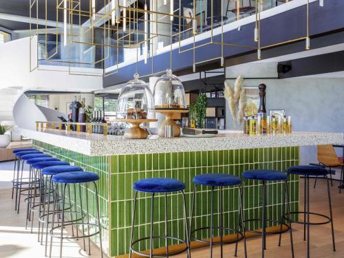 a bar with blue stools in front of a counter at ibis Nice Aéroport Promenade des Anglais in Nice