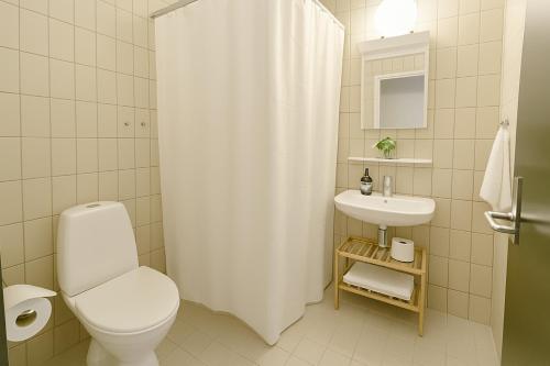 a white bathroom with a toilet and a sink at Hotel Svanegården in Korsør