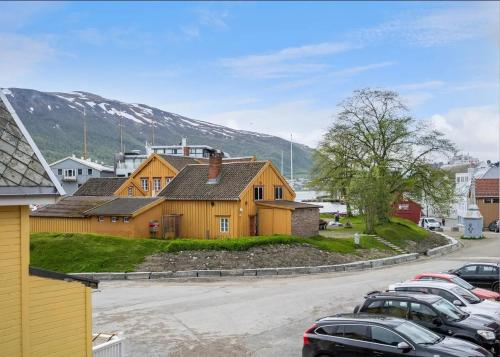 een groep huizen en auto's geparkeerd op een parkeerplaats bij Cottage studio in city centre in Tromsø