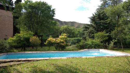 ein Swimmingpool im Gras neben einem Haus in der Unterkunft Abedules VGB in Villa General Belgrano