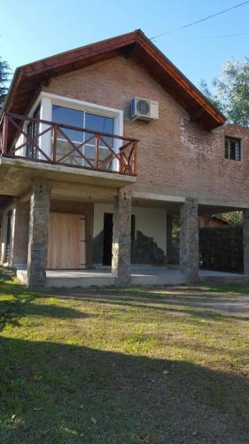 a house with a balcony on top of it at Abedules VGB in Villa General Belgrano