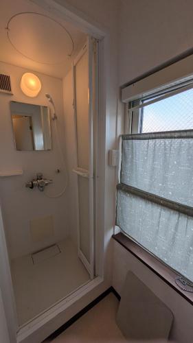 a bathroom with a shower and a sink and a mirror at Hakodate Stay Walk to Onsen and History in Hakodate