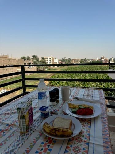 een tafel met twee borden eten op een balkon bij Villa Pure Luxor in Luxor