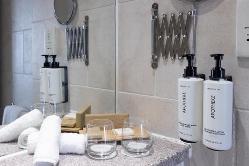 two bottles and glasses on a counter in a bathroom at Crowne Plaza Liverpool City Centre by IHG in Liverpool