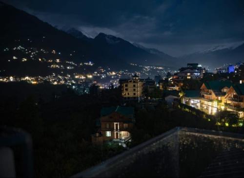 a view of a city at night at !!The Valley View Hill-Top Heights & Open Rooftop Cafe !! Bonfire !! Family Hotel Near To Mall Road 100Mtr!! in Vashisht