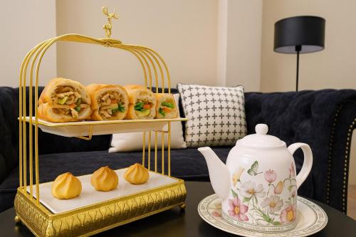 a table with a tray of pastries and a tea kettle at The Writeriana de Lumière in Ho Chi Minh City