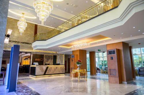 El vestíbulo de un hotel con lámparas de araña y una mesa en Aracan Hotac Ras El Bar, en Ras El Bar