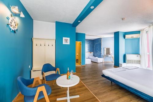 um quarto com paredes azuis e uma cama e cadeiras em Art Hotel Simona em Sófia