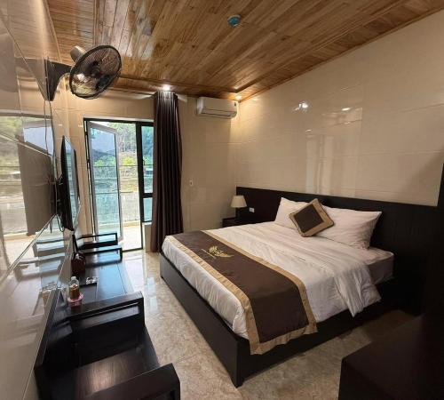 a bedroom with a bed and a desk and a television at Khách sạn Giang Sơn Bắc Hà Lào Cai in Bắc Hà