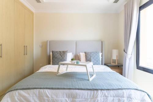 a bedroom with a bed with a table on it at Cozy 1-Bedroom In The Pearl - FGR3 in Doha