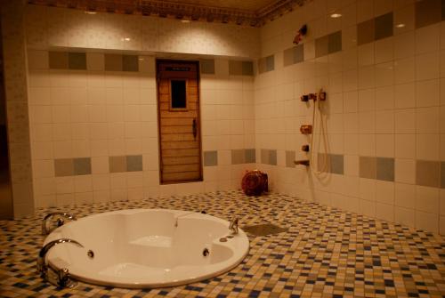 y baño con bañera en el suelo de baldosa. en Hotel PENTHOUSE Kanayama - Adult Only, en Nagoya