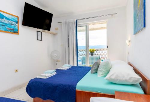 - une chambre avec un lit bleu et une vue sur l'océan dans l'établissement Apartments Boro, à Dugi Rat