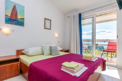 une chambre avec un lit avec vue sur l'océan dans l'établissement Apartments Boro, à Dugi Rat