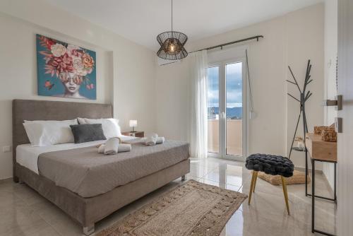 a bedroom with a bed and a large window at Athena Home South Crete in Kapparianá