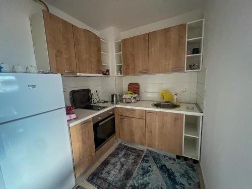 a small kitchen with wooden cabinets and a refrigerator at Bulevar in Sarajevo