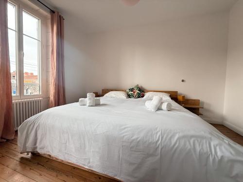 ein weißes Bett in einem Zimmer mit Fenster in der Unterkunft La villa Genette, Maison proche centre-ville in La Rochelle