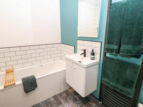ein Badezimmer mit Waschbecken und Badewanne und Waschbecken in der Unterkunft Cobble Cottage in Long Marton