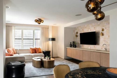 a living room with a couch and a tv at Hotel 55 Chicago Downtown in Chicago