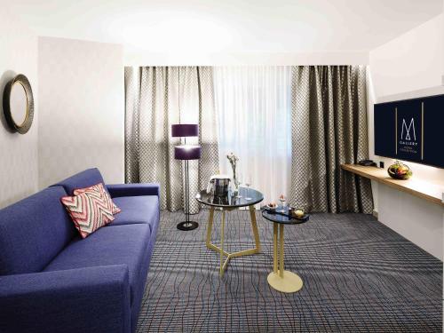 布雷根茨Grand Hotel Bregenz - MGallery Collection的客厅里有一张蓝色的沙发和一张桌子