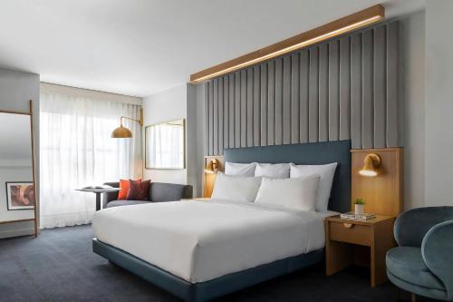 a hotel room with a large bed and a chair at Hotel 55 Chicago Downtown in Chicago