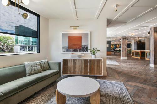 a living room with a couch and a table at FOUND Hotels, Santa Monica, Series by Marriott in Los Angeles