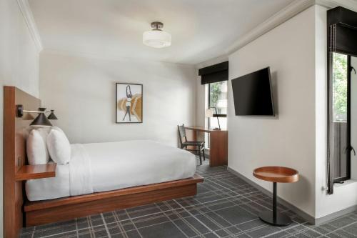 a bedroom with a bed and a flat screen tv at FOUND Hotels, Santa Monica, Series by Marriott in Los Angeles