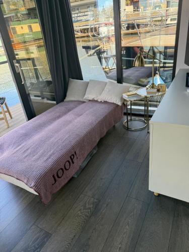 een bed in een kamer met een groot raam bij Lukrecja HouseBoat in Wrocław