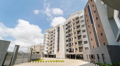 Un gran edificio de apartamentos blanco junto a una valla en The Cove Unit Ikate Lekki, en Lekki