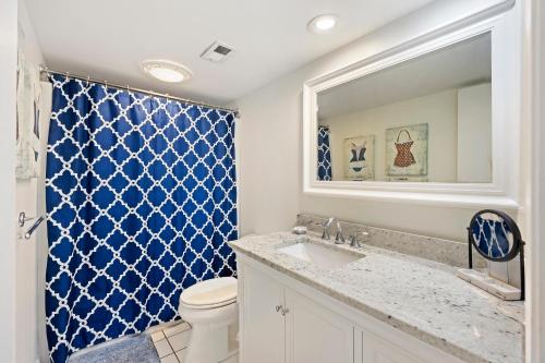 a bathroom with a toilet and a sink and a mirror at PW13105: 13105 Pelican Watch in Seabrook Island