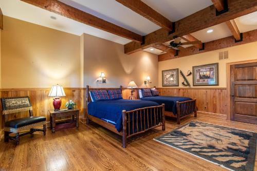a bedroom with two beds in a room with wooden walls at Amitola at Yonahlossee in Boone